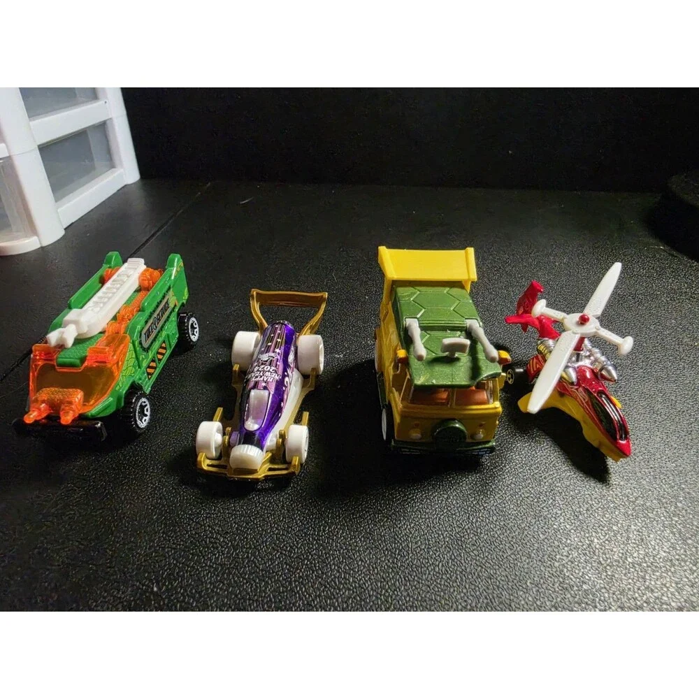 Lot of 4 loose Hot Wheels vehicles in pre-owned condition.